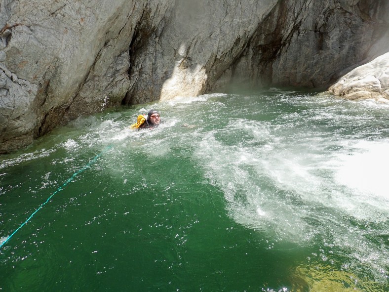 Hiker attempting to swim agains the waterfall current
